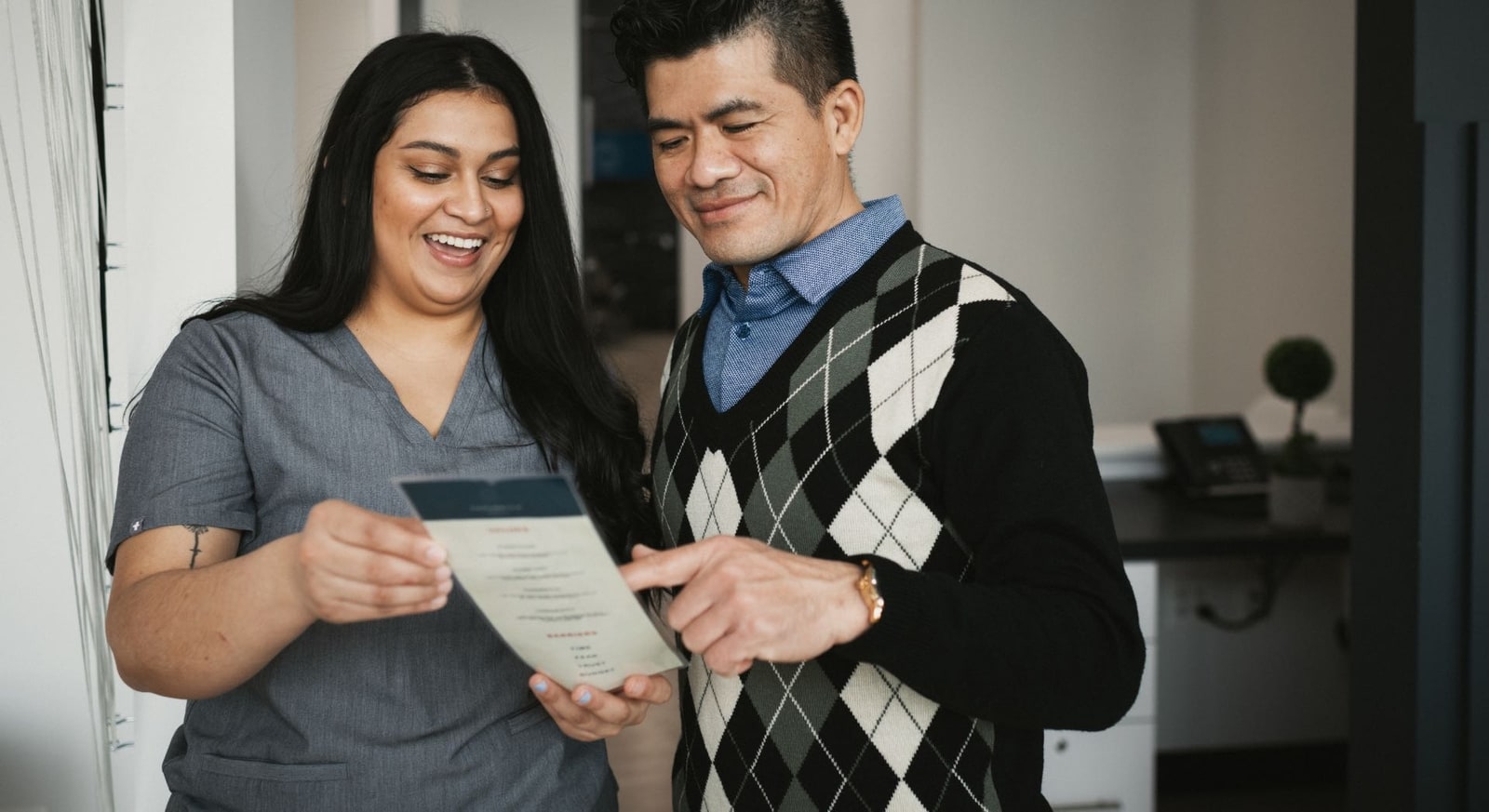 smiling dental staff member discusses treatment plan with patient in alexandria