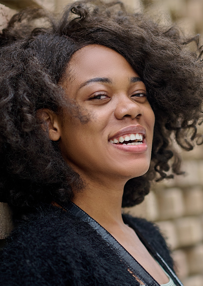 a woman smiling confidently with white teeth, showcasing results of a smile makeover